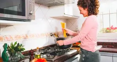 Mulher cozinhando no melhor cooktop 5 bocas